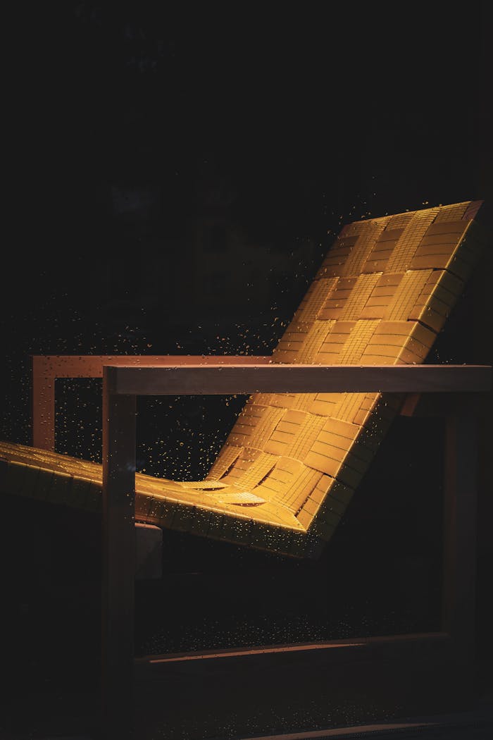 A sophisticated wooden chair with a woven seat, highlighted in a dark setting. Perfect for modern interiors.