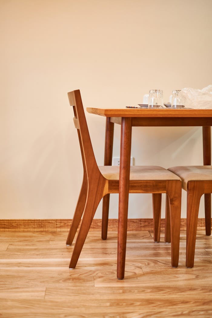 Elegant wooden dining table and chairs in a minimalist interior setting.